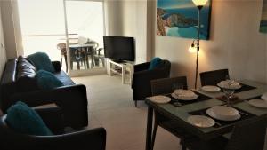 a living room with a couch and a table and chairs at Sea View Penthouse Apartment Monte Pego in Pego