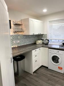 a kitchen with a sink and a washing machine at Entire Modern Apartment in Oban with Balcony in Oban