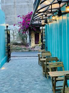 a group of wooden tables and benches outside a building at Villa Bordeaux in Puducherry