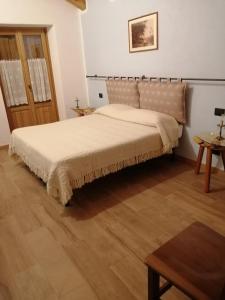 1 dormitorio con 1 cama grande y suelo de madera en La scuola en Riclaretto