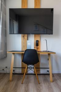 a desk with a chair and a flat screen tv at HOTEL SØMA Nuuk in Nuuk