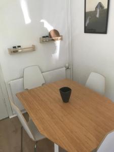 a dining room with a wooden table and white chairs at Hus ved skov in Ejby