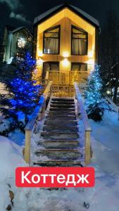 a house with christmas lights in the snow at Вилла Zlata in Bukovel