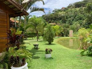 einen Garten mit Pflanzen und einer Bank im Hof in der Unterkunft Chácara em Marechal Floriano in Marechal Floriano