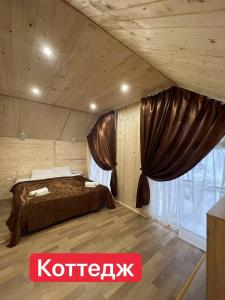a bedroom with a bed and a large window at Вилла Zlata in Bukovel