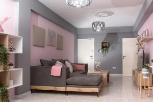 sala de estar con sofá gris y paredes rosas en Callisto 3 Bedroom Apartment en Lárnaca