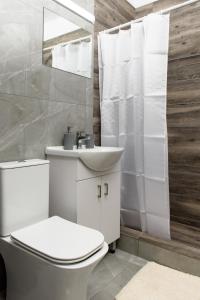Baño blanco con aseo y lavamanos en Callisto 3 Bedroom Apartment en Lárnaca