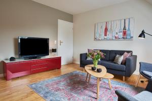 uma sala de estar com um sofá e uma televisão em Heidehaus Wohnung 02 em Wyk auf Föhr