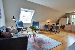 uma sala de estar com um sofá, cadeiras e uma mesa em Heidehaus Wohnung 02 em Wyk auf Föhr