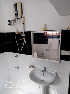 ein Badezimmer mit einem Waschbecken und einem Telefon an der Wand in der Unterkunft La-Vira Beach Villa in Hikkaduwa