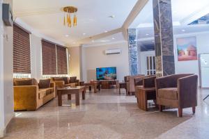 a waiting room with couches and tables and a tv at Guest Pride Hotel in Kano