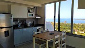 a kitchen with a table with chairs and a refrigerator at PentHouse con fantástica vista y Amenities únicos in Punta del Este