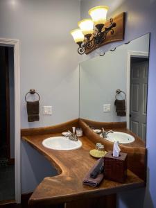 Makanda的住宿－Makanda Inn，一间带两个盥洗盆和大镜子的浴室