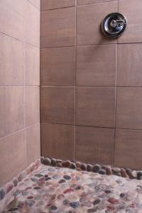a shower with a stone floor in a shower stall at Makanda Inn in Makanda