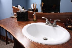 Makanda的住宿－Makanda Inn，浴室柜台配有白色水槽和镜子