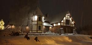 zwei Menschen laufen im Schnee vor einem Haus in der Unterkunft Apartamenty Milenijna 2 MALBORK Nowa Wieś in Malbork