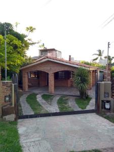 a brick house with a driveway in front of it at Casa Tranquila en pasaje , Villa Carlos Paz in Villa Carlos Paz