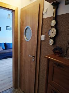 a wooden door with a mirror and a clock on a wall at NoclegwGdyni24 in Gdynia
