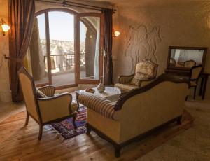 a living room with two chairs and a window at Arif Cave Hotel in Göreme