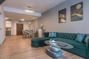 a living room with a green couch and a table at Green Luxury Apartments in Burgas City