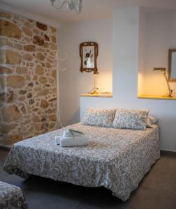 1 dormitorio con cama y pared de piedra en Alojamiento rural La Granja de Las Monjas, en Jaén