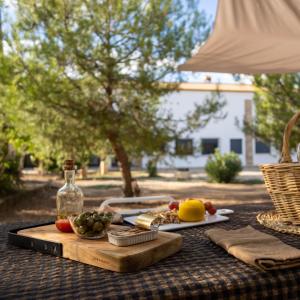 einen Tisch mit einem Schneidebrett mit Obst und Gemüse in der Unterkunft Alojamiento rural La Granja de Las Monjas in Jaén