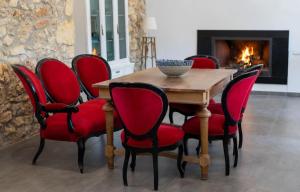 une salle à manger avec une table en bois et des chaises rouges dans l'établissement Alojamiento rural La Granja de Las Monjas, à Jaén