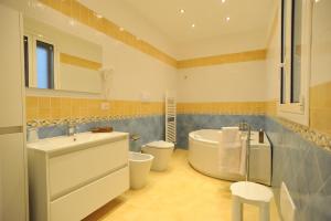 a bathroom with a tub and a toilet and a sink at Italiana Resort in Floridia +31 photos