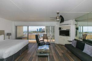 um quarto com uma cama, um sofá e uma televisão em Ilikai Tower 1033 Yacht Harbor View 1BR em Honolulu