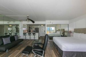 a bedroom with a large bed and a living room at Ilikai Tower 1033 Yacht Harbor View 1BR in Honolulu