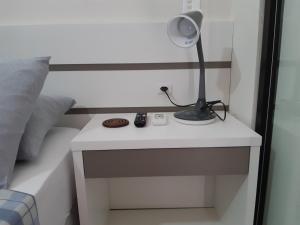 a lamp on a white table next to a bed at Casa temporada Beto Carrero in Penha +22 photos