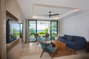 un soggiorno con divano blu e TV di Iguana Beach House a Iguana