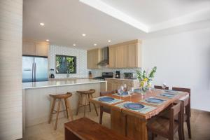 a kitchen with a wooden table with chairs and a counter at Iguana Beach House in Iguana