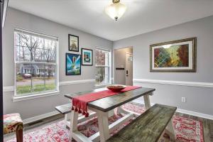 uma sala de jantar com uma mesa e duas janelas em Charming 3-Bedroom Home in Heart of Ashland em Ashland