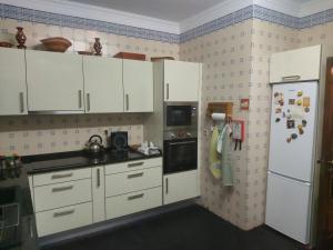 eine Küche mit weißen Schränken und einem Kühlschrank in der Unterkunft Lavra Beach House in Lavra