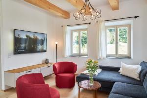 salon z niebieską kanapą i czerwonymi krzesłami w obiekcie Seechalet Traunsee w mieście Ort