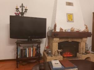 sala de estar con TV y chimenea en Lavra Beach House, en Lavra