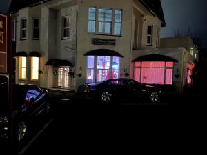 a car parked in front of a house at night at Cecil Court Hotel in Bournemouth