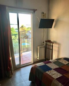 a bedroom with a bed and a sliding glass door at Paz y Armonia Habitaciones in Mina Clavero