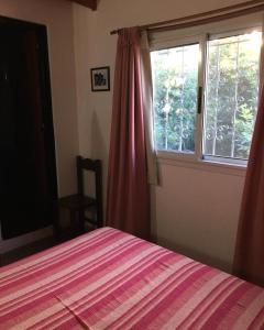 a bedroom with a bed and a window at Paz y Armonia Habitaciones in Mina Clavero