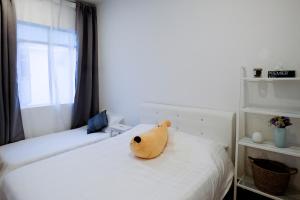 a teddy bear sitting on top of a bed at Comfy Sofy 21- Backyard Garden- Night Market area in Cameron Highlands