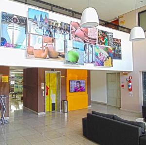 a lobby with couches and posters on the wall at Expresso R1 Hotel Economy Suites in Maceió