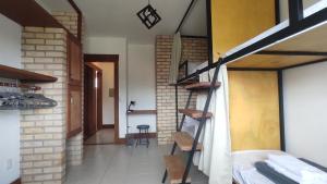 a room with a staircase and a brick wall at Patz Houz Hostel in Florianópolis