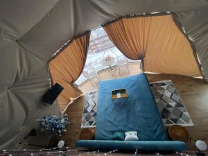 a view of a tent with a blue couch in it at Karpatski Dzherela in Yaremche