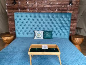 a blue bed with a blue tufted head board at Karpatski Dzherela in Yaremche