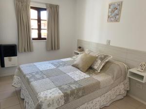 1 dormitorio con 1 cama y TV en Oasis del Sur en Puerto Madryn