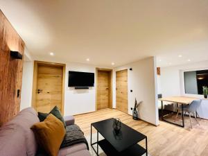 salon z kanapą i stołem w obiekcie Schöne Wohnung mit Ausblick, Sauna und Hot-Pot in Westendorf, Tirol w mieście Westendorf
