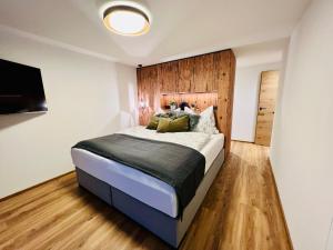 sypialnia z dużym łóżkiem z drewnianym zagłówkiem w obiekcie Schöne Wohnung mit Ausblick, Sauna und Hot-Pot in Westendorf, Tirol w mieście Westendorf