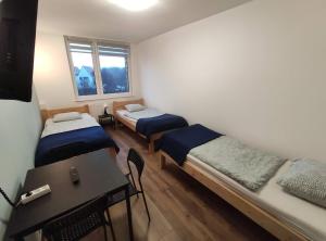 um quarto com duas camas e uma mesa em Night Point em Racibórz