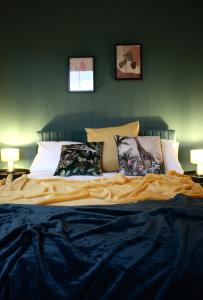 a bed in a bedroom with green walls and pillows at The Velveteen Townhouse in Colchester